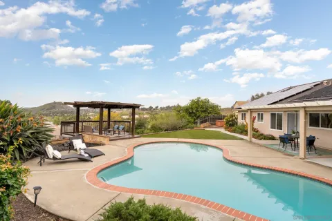 a view of a house with swimming pool and sitting area
