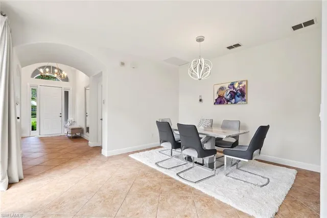 a living room with stainless steel appliances granite countertop furniture a fireplace a flat screen tv and a refrigerator