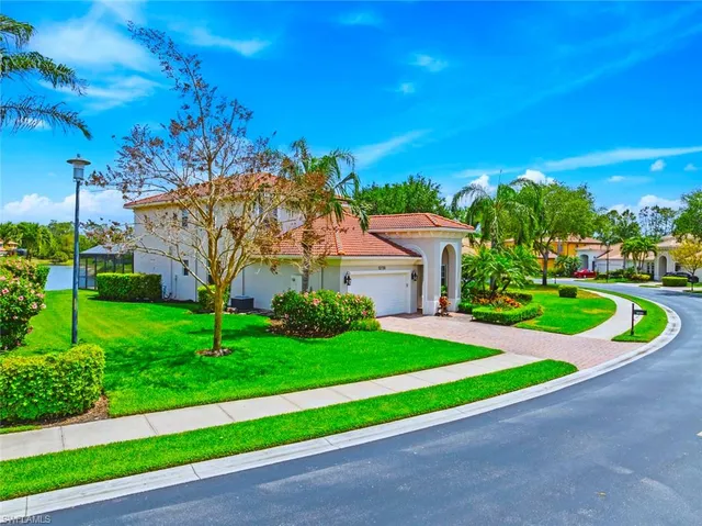 a view of a house with a yard and potted plants