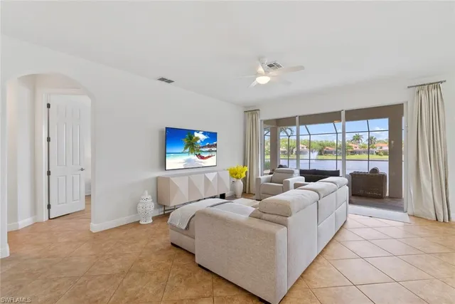 a living room with furniture kitchen view and a large window