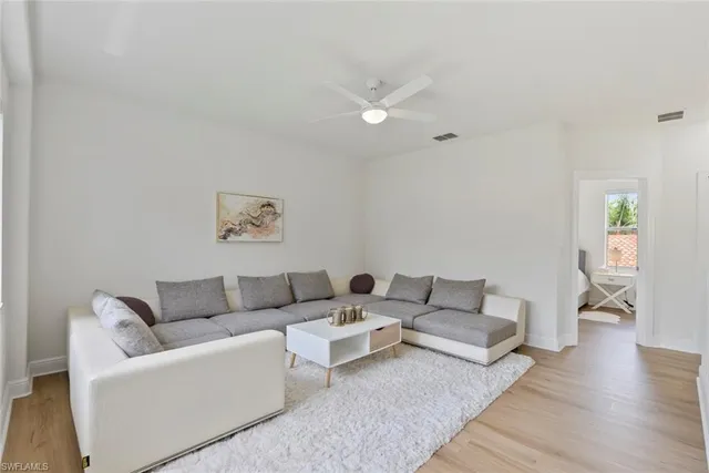 a bedroom with a bed a dresser and a chandelier
