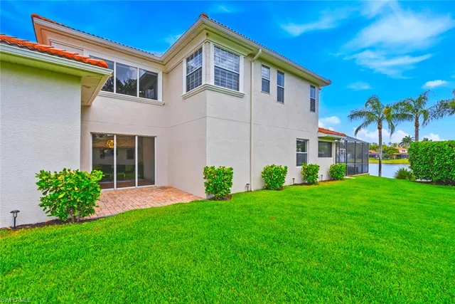a front view of a house with a yard and trees