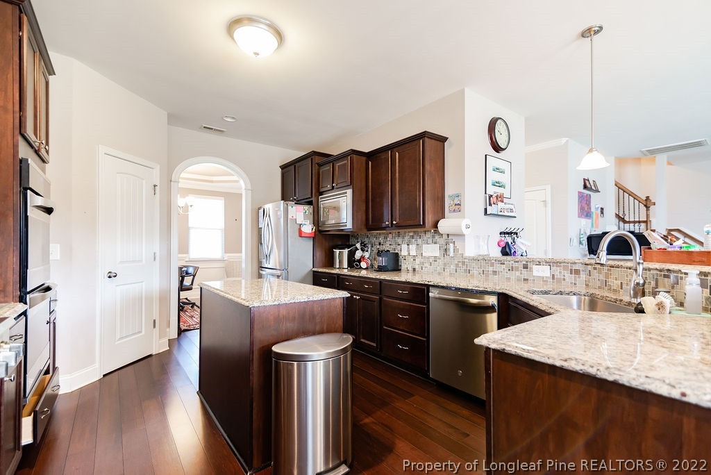 335 Turriff Way Cameron, NC 28326 - Photo 20 of 50 a kitchen with granite countertop a sink stove and refrigerator