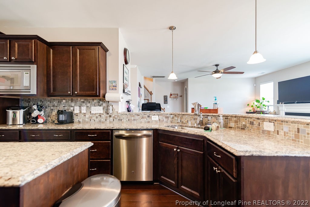 335 Turriff Way Cameron, NC 28326 - Photo 21 of 50 a kitchen with stainless steel appliances granite countertop a sink a stove and a wooden cabinets