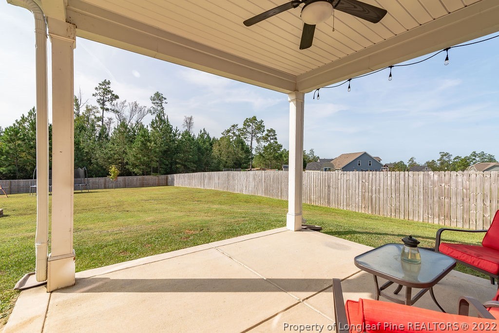335 Turriff Way Cameron, NC 28326 - Photo 47 of 50 a view of a backyard with table and chairs potted plants with wooden floor and fence