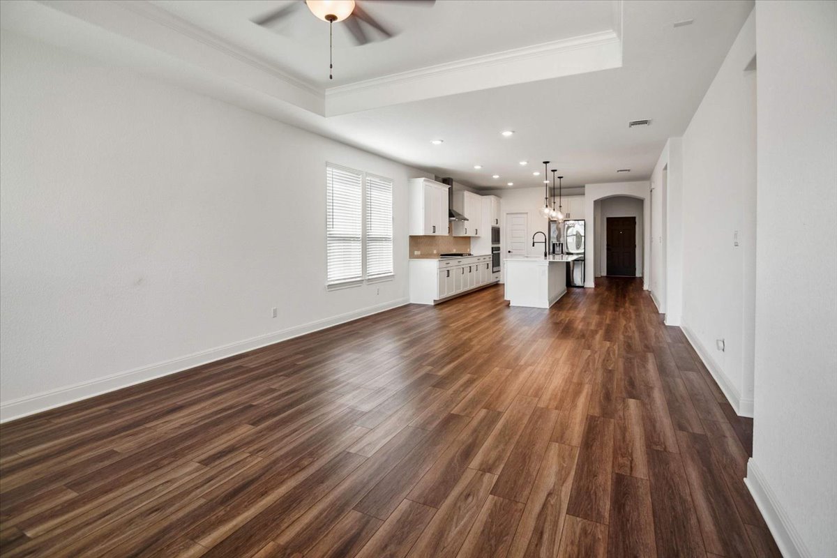 104 Raleigh Drive Georgetown, TX 78633 - Photo 8 of 37 An open-concept living area with lustrous hardwood flooring flows seamlessly into a contemporary kitchen.