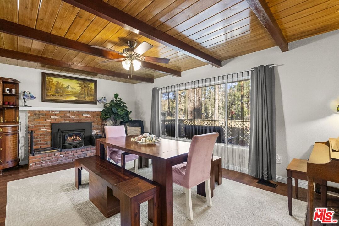 1197 Oriole Road Wrightwood, CA 92397 - Photo 2 of 50 a dining room with furniture a fireplace and wooden floor