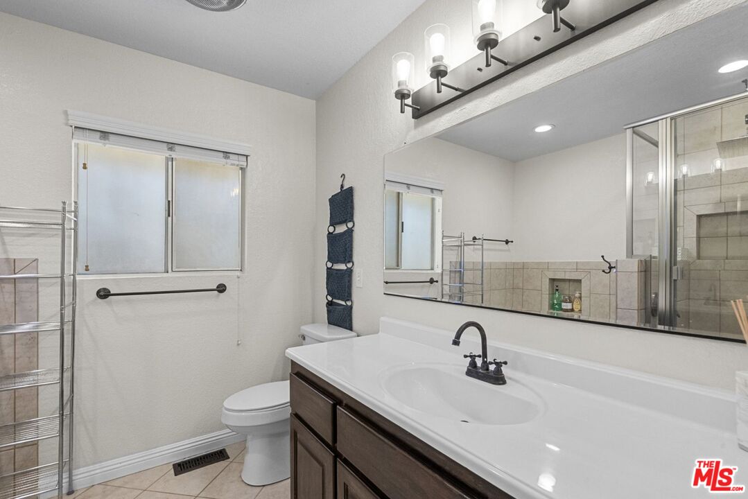1197 Oriole Road Wrightwood, CA 92397 - Photo 33 of 50 a bathroom with a sink a toilet a mirror and shower