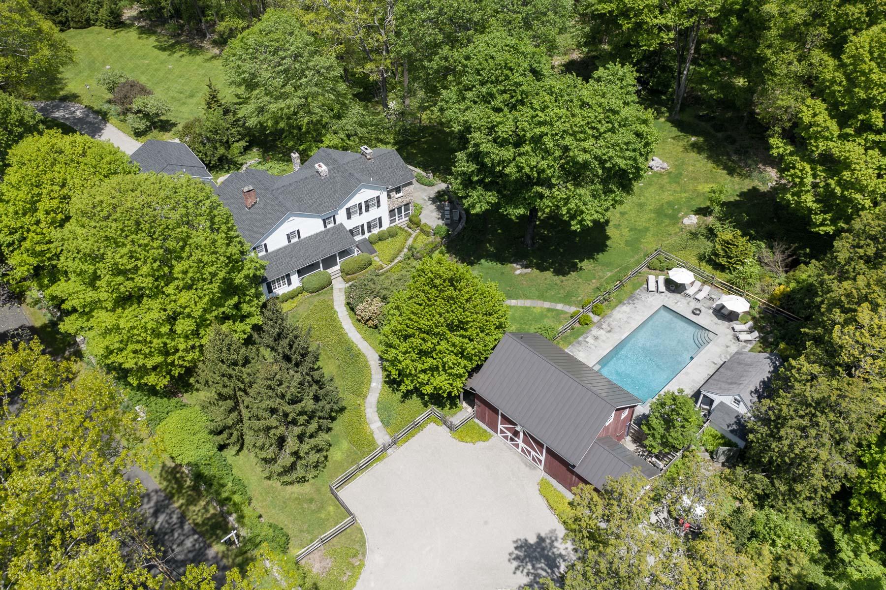 an aerial view of a house with a yard lake and outdoor seating
