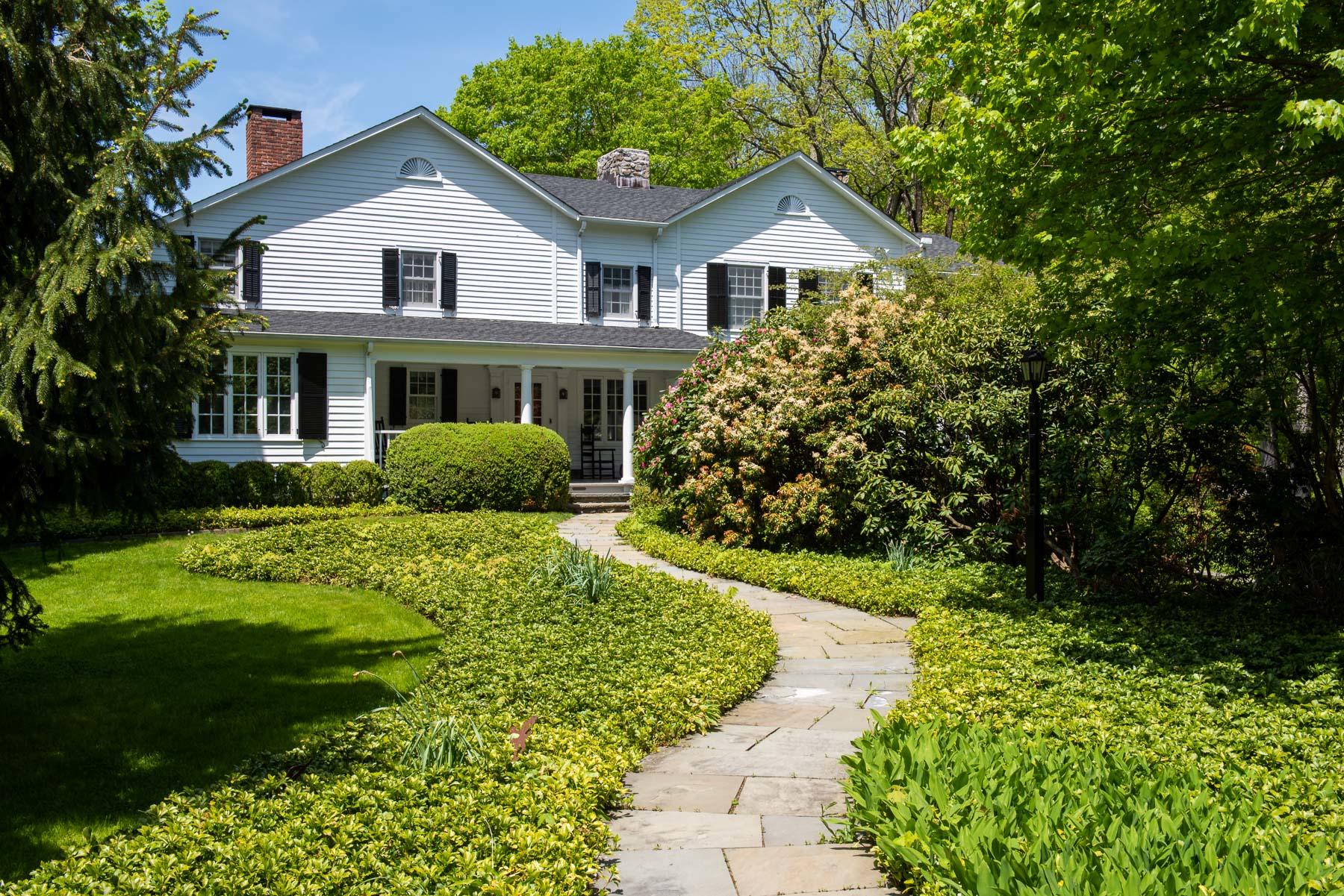 1403 Ponus Ridge Road New Canaan, CT 06840 - Photo 4 of 48 a front view of a house with a yard and trees