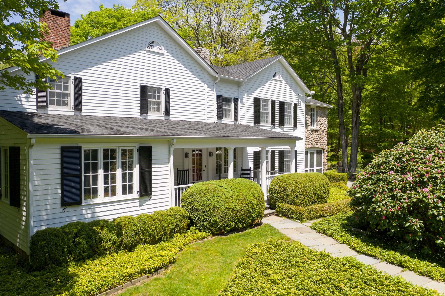 1403 Ponus Ridge Road New Canaan, CT 06840 - Photo 5 of 48 a front view of a house with a yard and potted plants