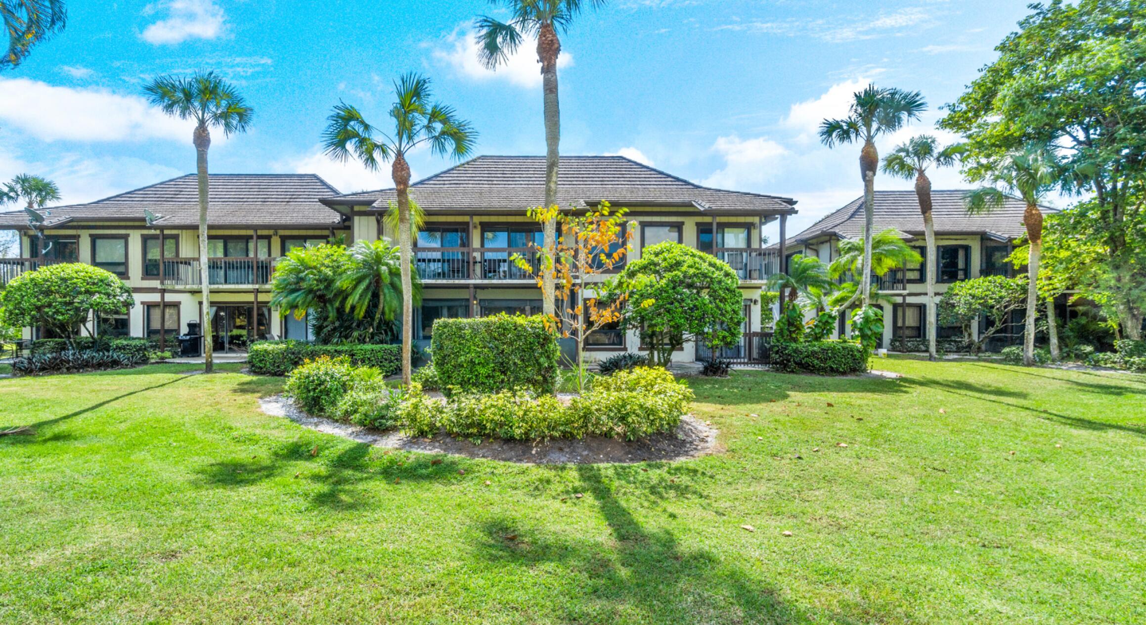 13334 Polo Club Road, Unit 216 Wellington, FL 33414 - Photo 1 of 9 a view of a house with a yard and potted plants