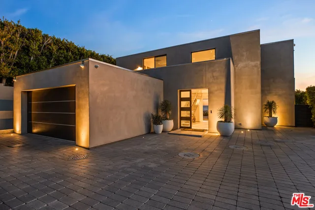 a kitchen with a stove a microwave and living room view