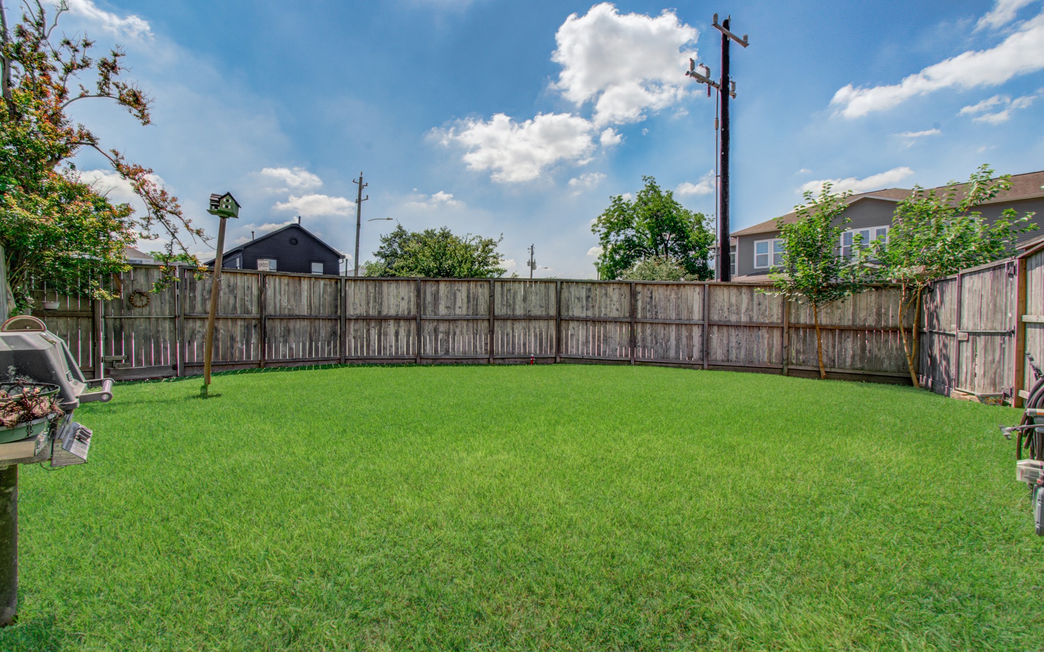 6621 North Main Street Houston, TX 77009 - Photo 32 of 41 Spacious backyard with lush green grass, enclosed by a wooden fence, perfect for outdoor activities and privacy.