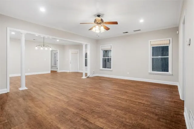 a view of an empty room with window and wooden floor