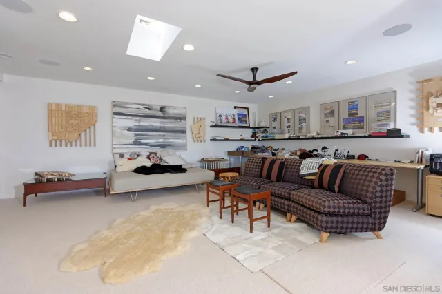 a living room with furniture kitchen view and a chandelier