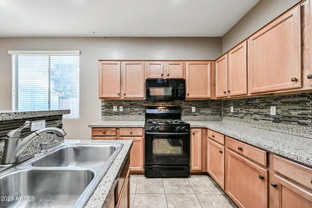 a kitchen with stainless steel appliances granite countertop a sink stove and microwave