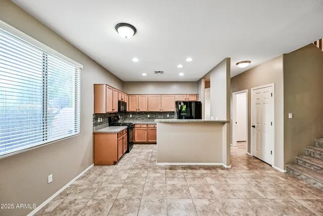 a view of kitchen with stainless steel appliances granite countertop refrigerator sink and cabinets