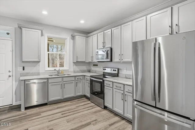 a kitchen with stainless steel appliances granite countertop a refrigerator sink and stove