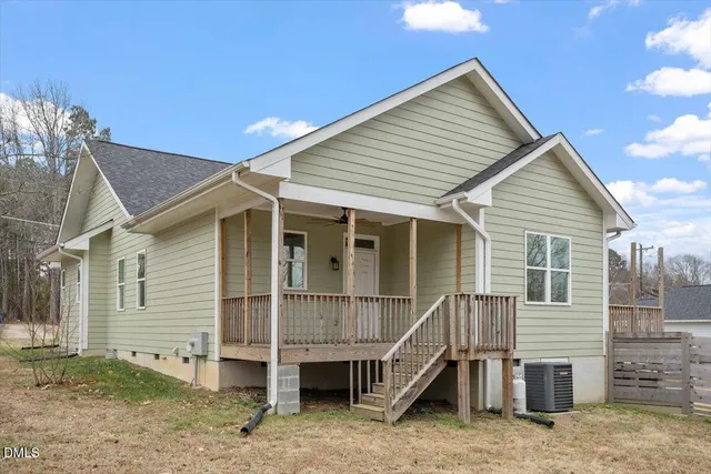 a small white house with a white roof and table and chairs