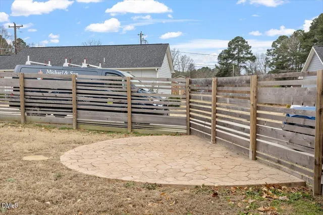 a view of a house with a wooden fence