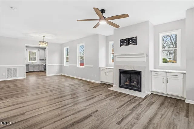 an empty room with windows and fireplace