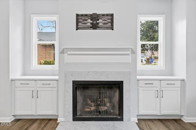 a living room with a fireplace and a painting on the wall