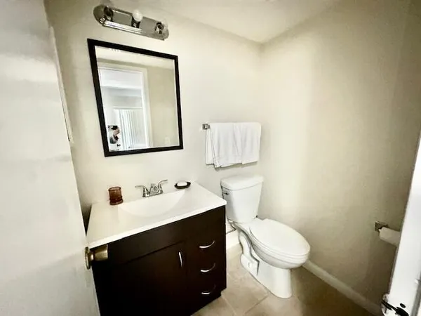 a bathroom with a toilet sink vanity and mirror