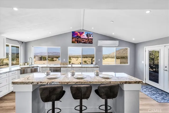 a dining hall with stainless steel appliances granite countertop a sink stove and refrigerator