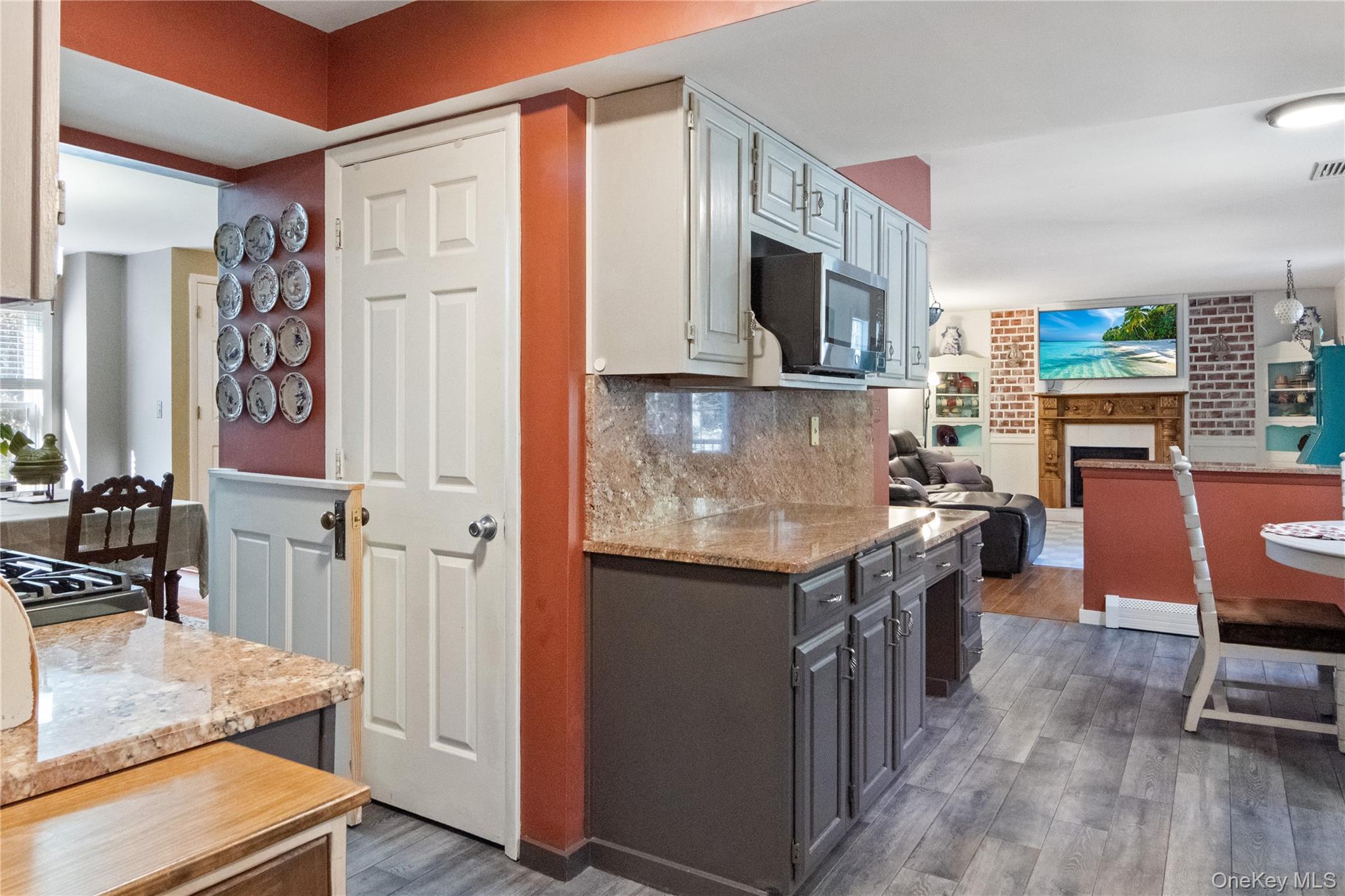 12 Chapel Road Newburgh, NY 12550 - Photo 14 of 46 a kitchen with stainless steel appliances granite countertop a stove top oven a sink dishwasher a dining table and chairs with wooden floor