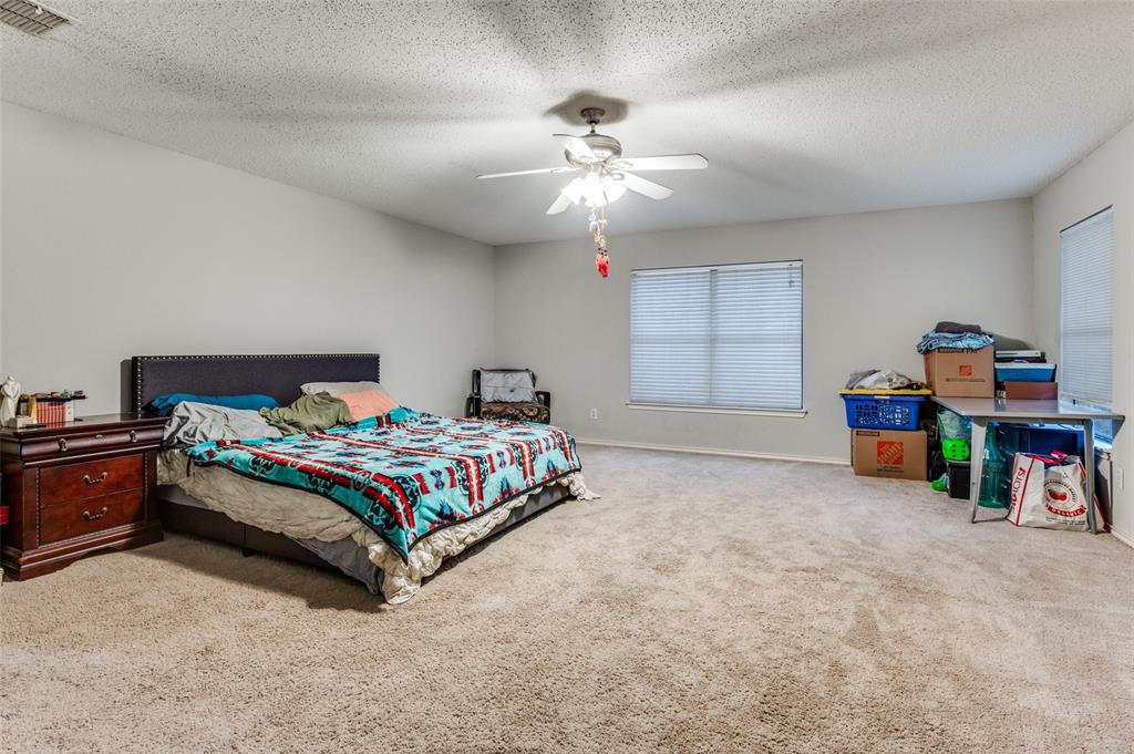 4254 Birch Creek Road Fort Worth, TX 76244 - Photo 15 of 25 a bedroom with bed and a chandelier