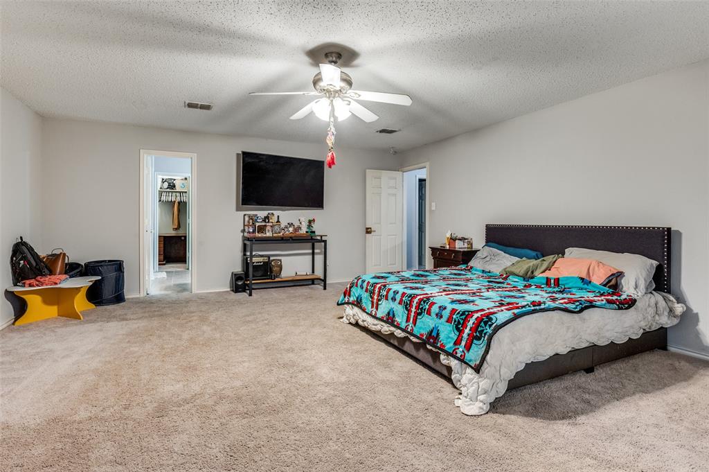4254 Birch Creek Road Fort Worth, TX 76244 - Photo 16 of 25 a bedroom with a bed and a flat screen tv