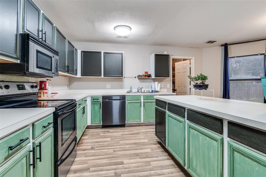 4254 Birch Creek Road Fort Worth, TX 76244 - Photo 8 of 25 a kitchen with stainless steel appliances granite countertop a sink and a stove top oven
