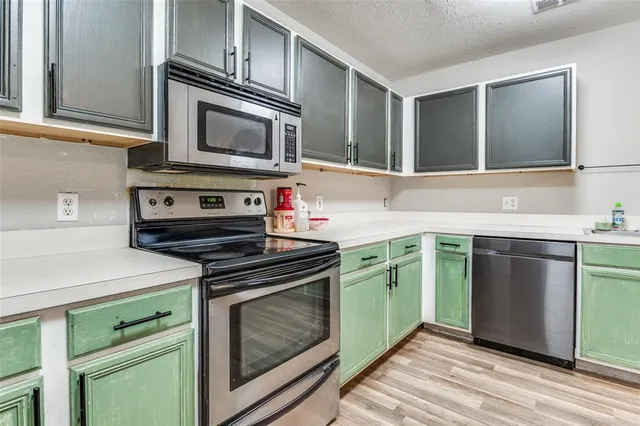 a kitchen with cabinets a sink and stainless steel appliances