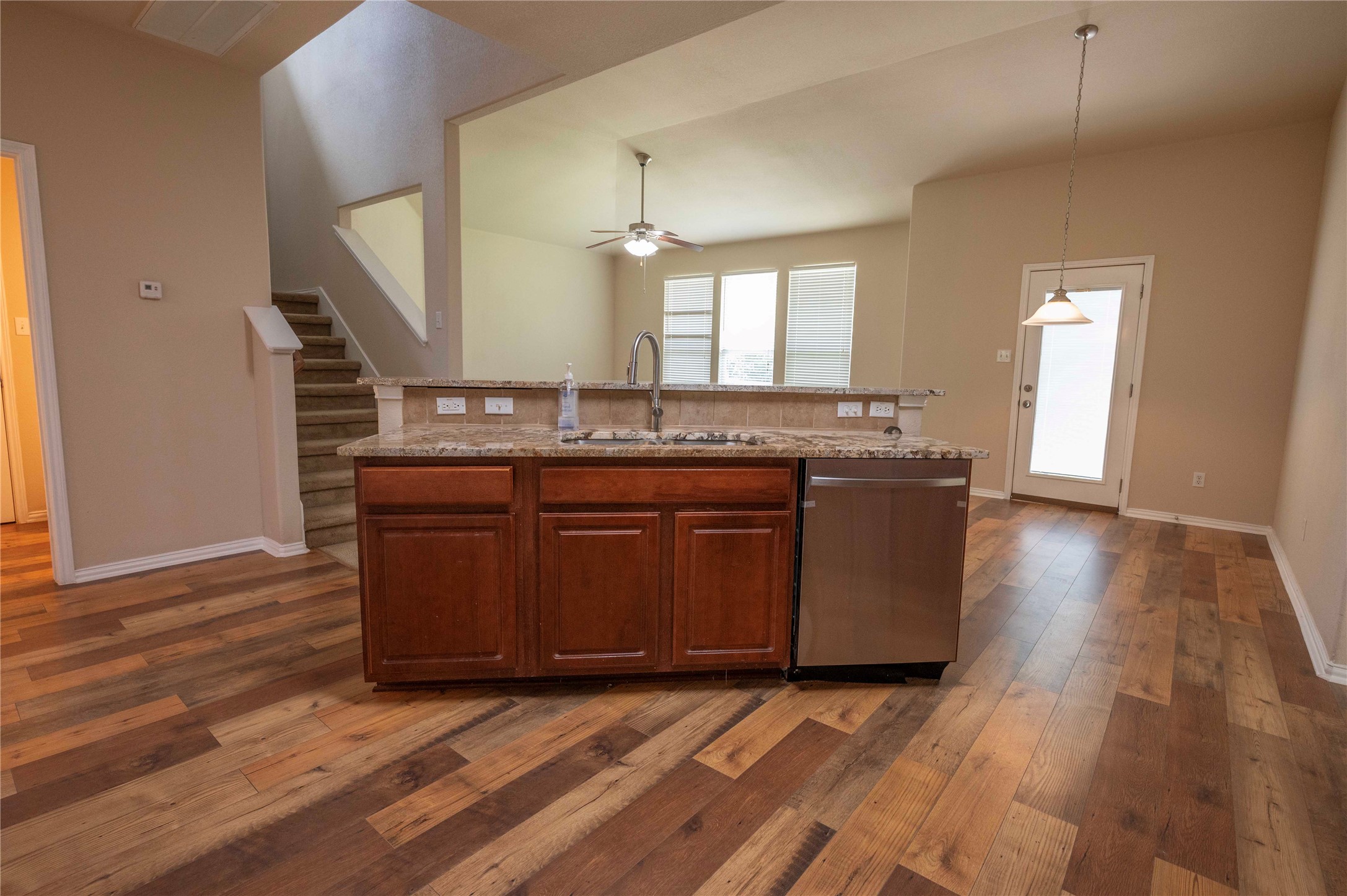 2070 Intrepid Drive Buda, TX 78610 - Photo 6 of 31 A well-appointed kitchen island with a gleaming stainless steel dishwasher anchors this welcoming open-concept living space.
