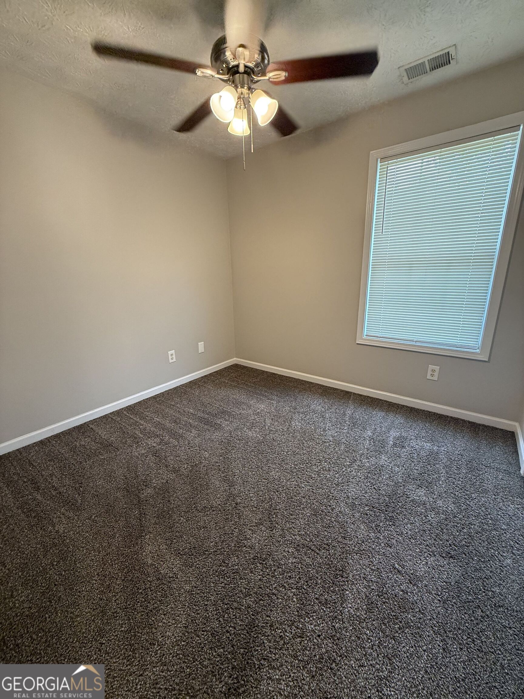 6132 Ruth Street Southwest Covington, GA 30014 - Photo 22 of 33 an empty room with a window and a fan