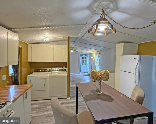 a kitchen with a table chairs and a refrigerator