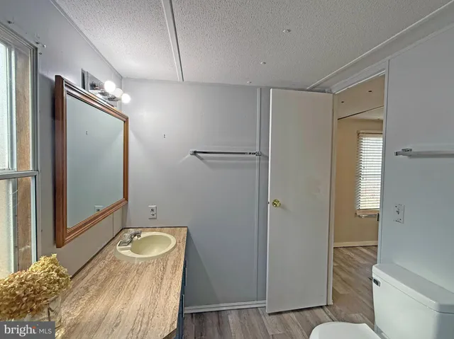 a bathroom with a granite countertop sink mirror vanity and toilet