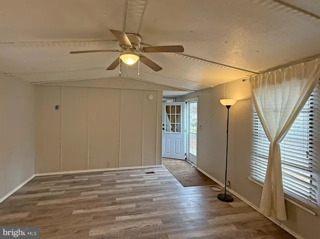a view of a room with wooden floor and white walls