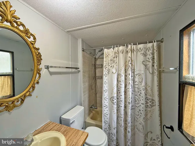 a bathroom with a shower curtain and a mirror