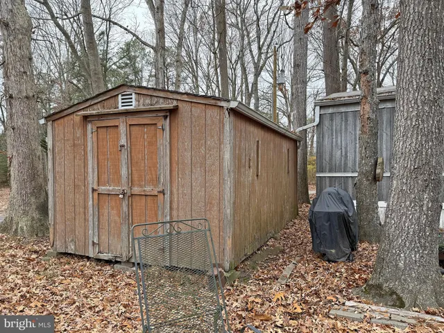a view of a wooden house with a bench and wooden fence