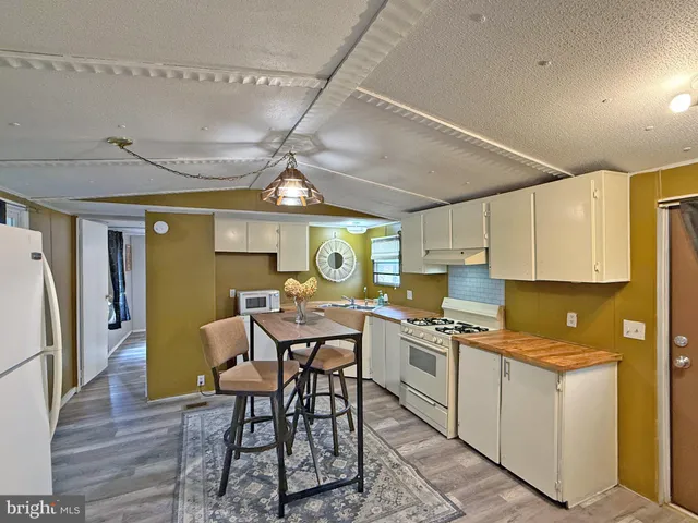 a view of a kitchen with a dining table and chairs