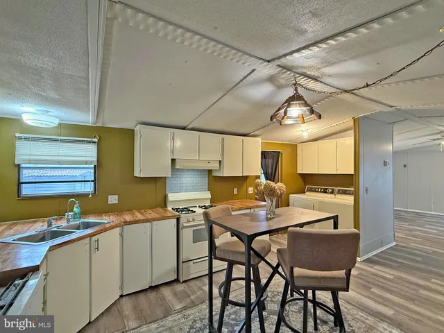 a kitchen with a sink cabinets and wooden floor