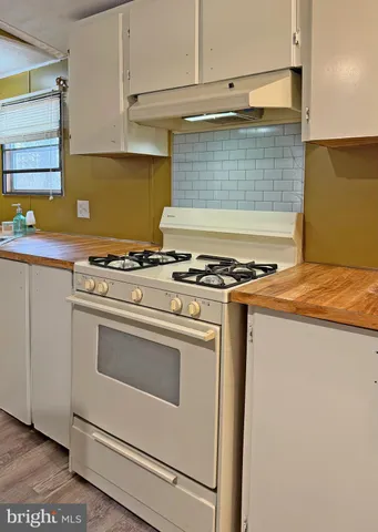 a kitchen with granite countertop a stove and a wooden cabinets