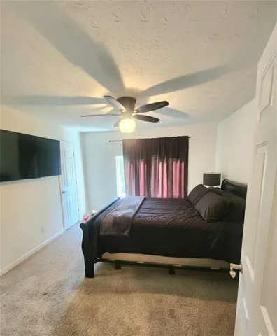 a bedroom with a bed and a ceiling fan