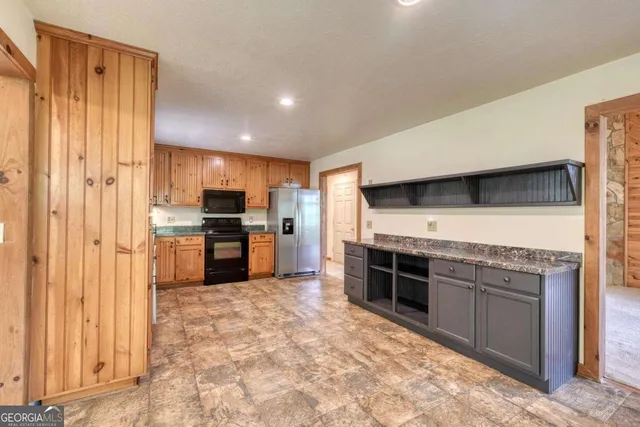 a kitchen with granite countertop appliances cabinets and a sink