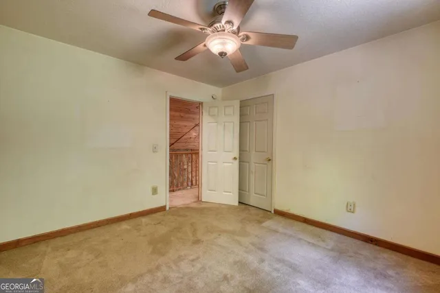 a view of an empty room with a ceiling fan