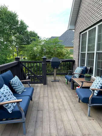 a view of a patio with couches chairs and wooden floor