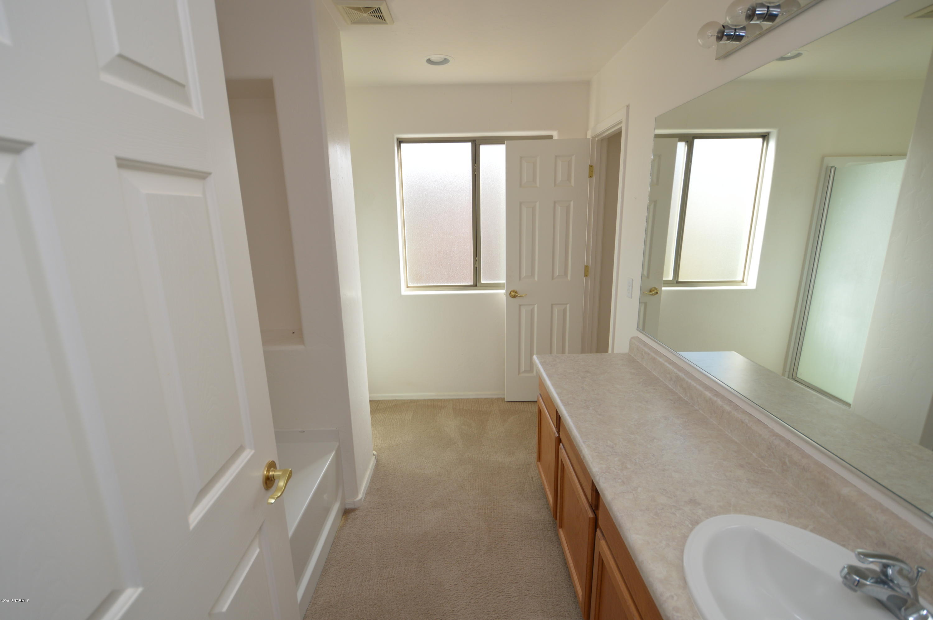 8396 West Benidorm Loop Tucson, AZ 85757 - Photo 10 of 13 a bathroom with a granite countertop sink a mirror and a bathtub