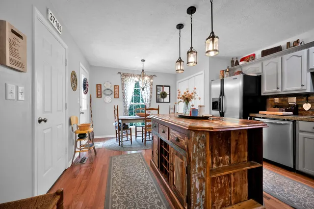 a kitchen with kitchen island granite countertop a sink a center island and cabinets